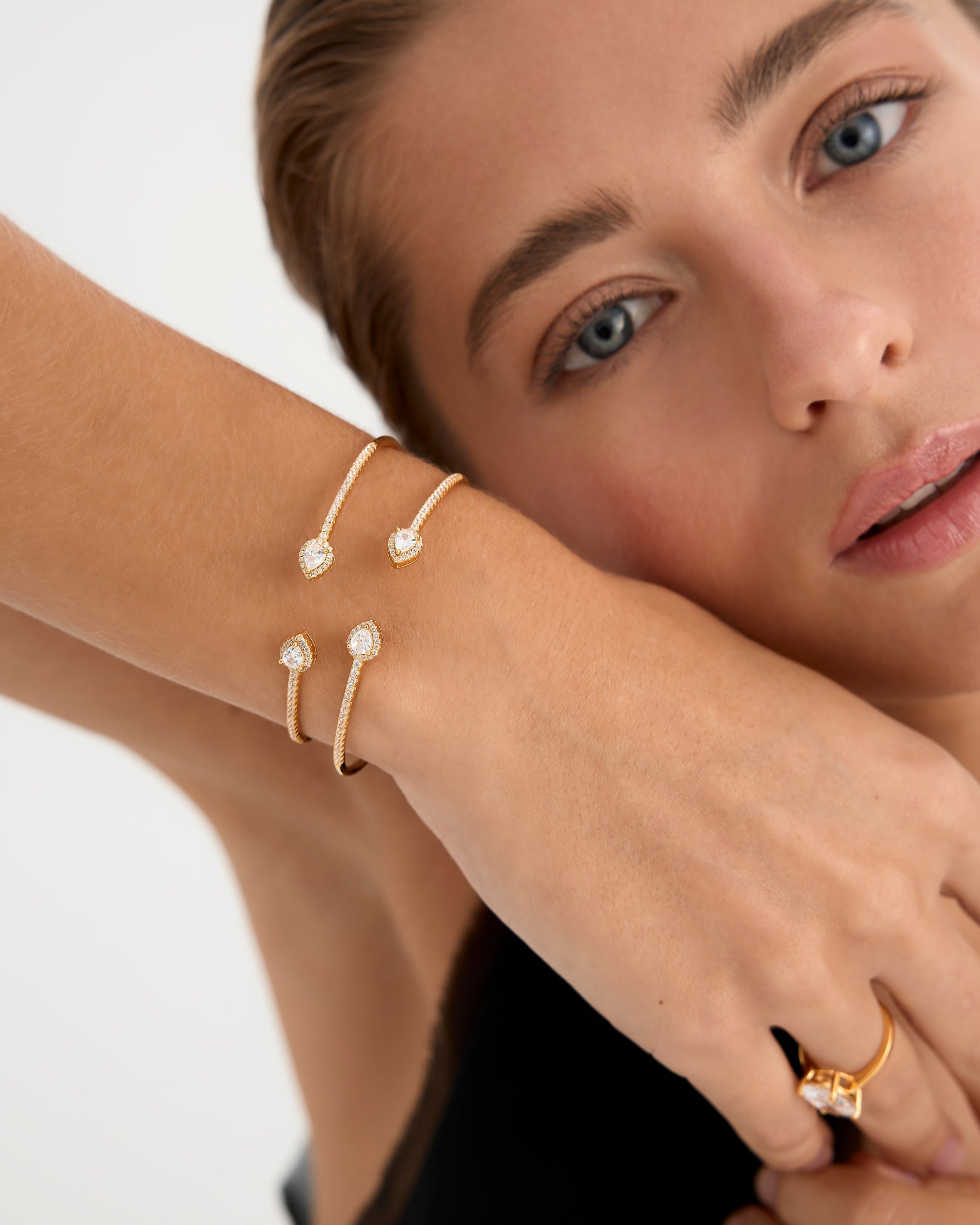 Pulsera Gala en plata de ley 925 con baño de oro amarillo de 18kts, decorada con circonitas blancas y piedras en talla pera de 2 mm. Inspirada en las galas de los años 20, con diámetro de 17 mm y cierre ajustable